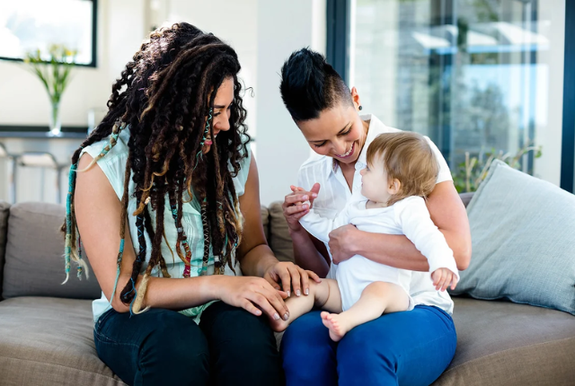 A Lady with her surrogate sitting and laughing with the baby